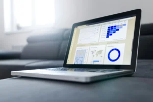 Portátil com dashboard de análise de dados e gráficos apresentado no ecrã.